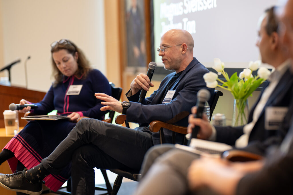 panelist speaker holding a microphone speaking to an audience