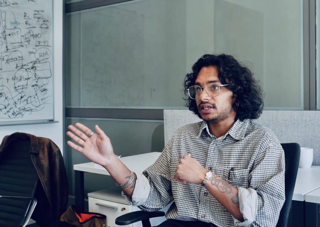 Varun Satish speaking in an office